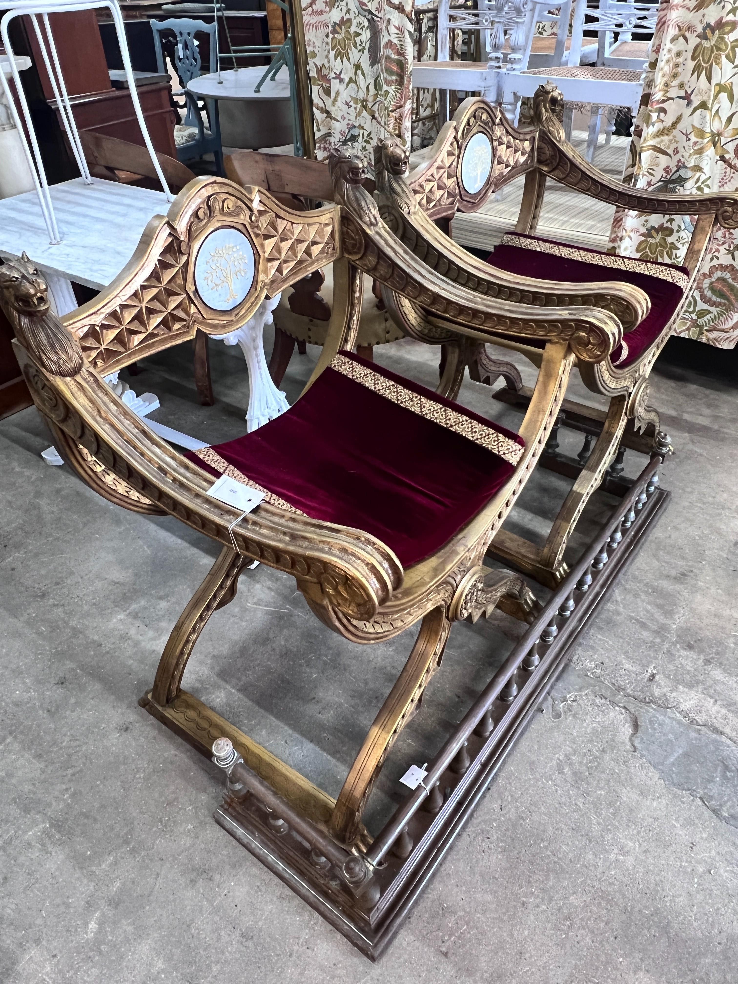A pair of Renaissance style giltwood and composition X frame elbow chairs, on lion's paw feet, width 73cm, depth 59cm, height 99cm